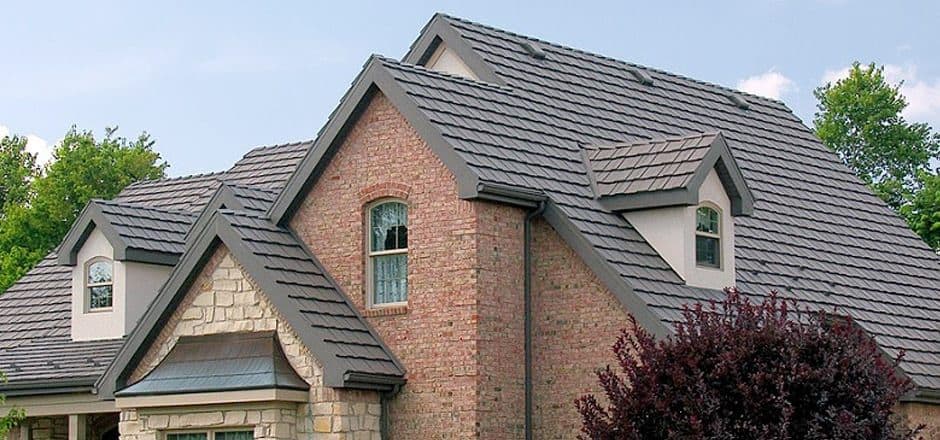 A brick house with a gray metal roof.