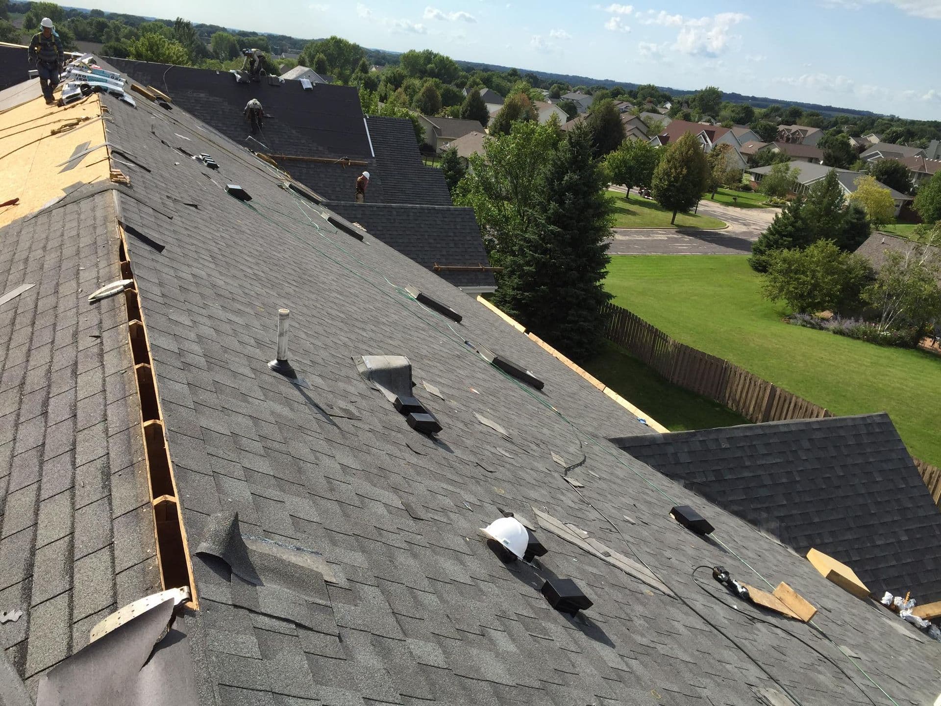 A gray asphalt shingle roof in the process of being replaced.
